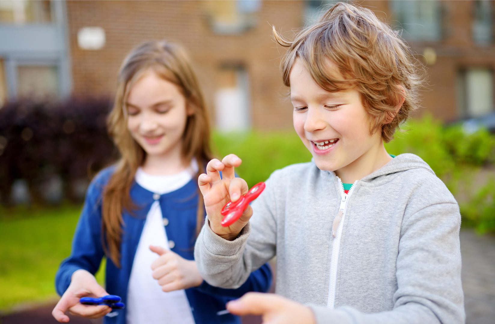 Two children are playing with a pair of scissors.