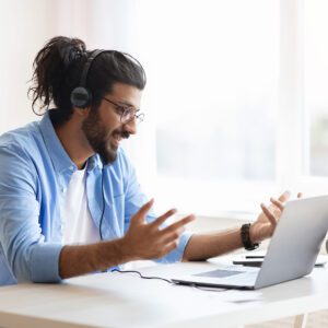 A man wearing headphones and using a laptop.